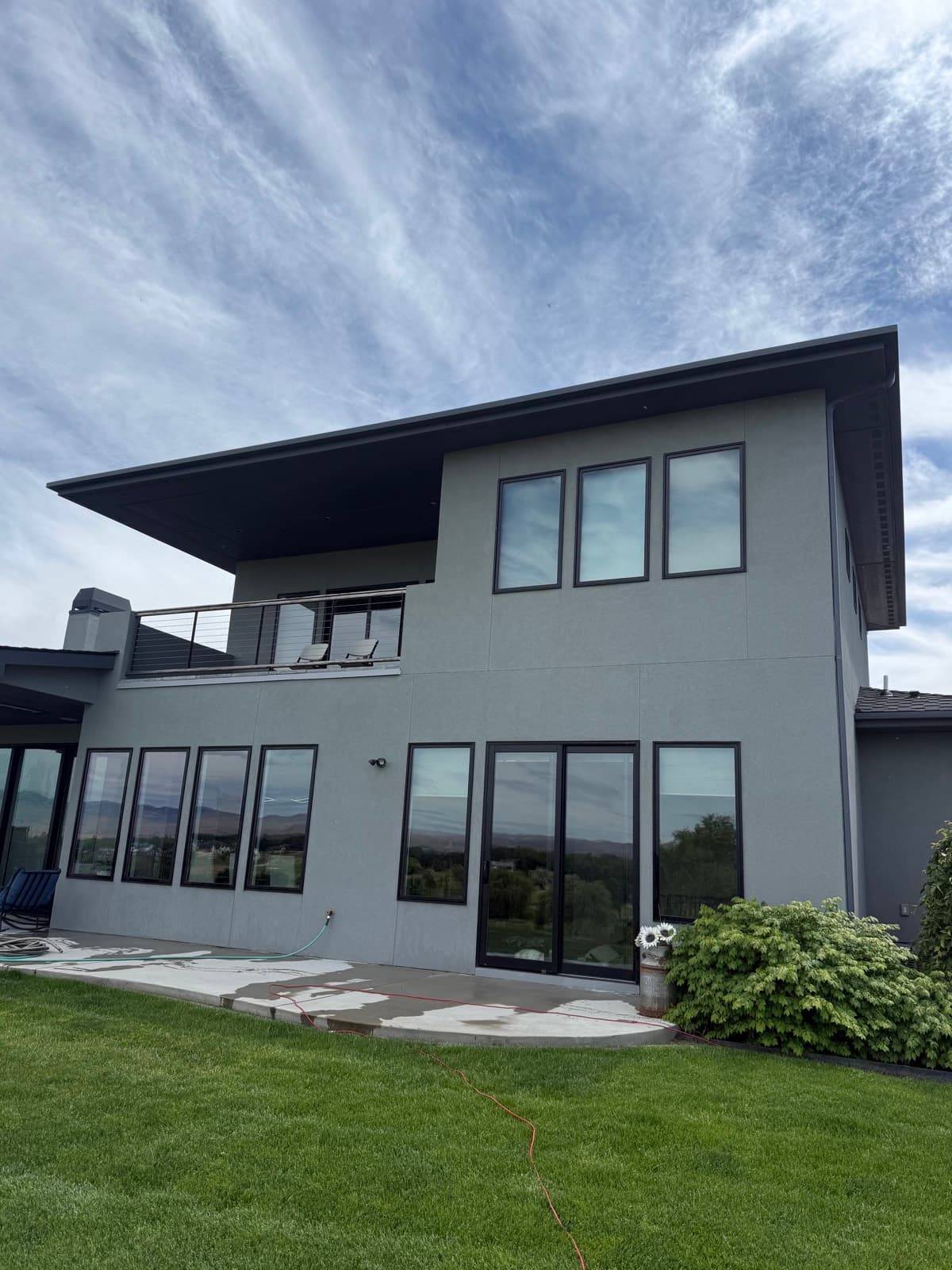 Modern gray two-story home with a clean back patio