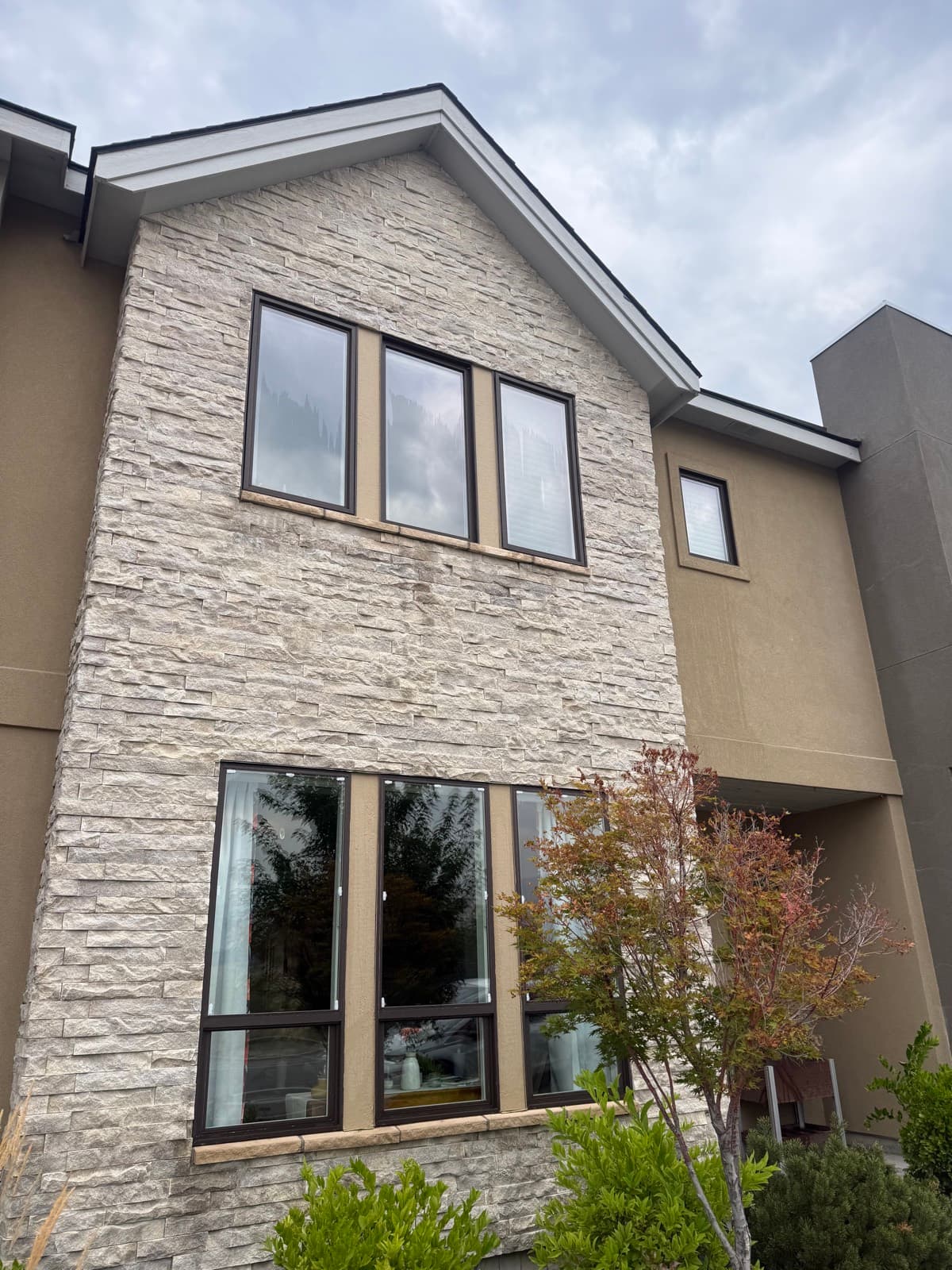 Two-story stone home with crisp, clean windows