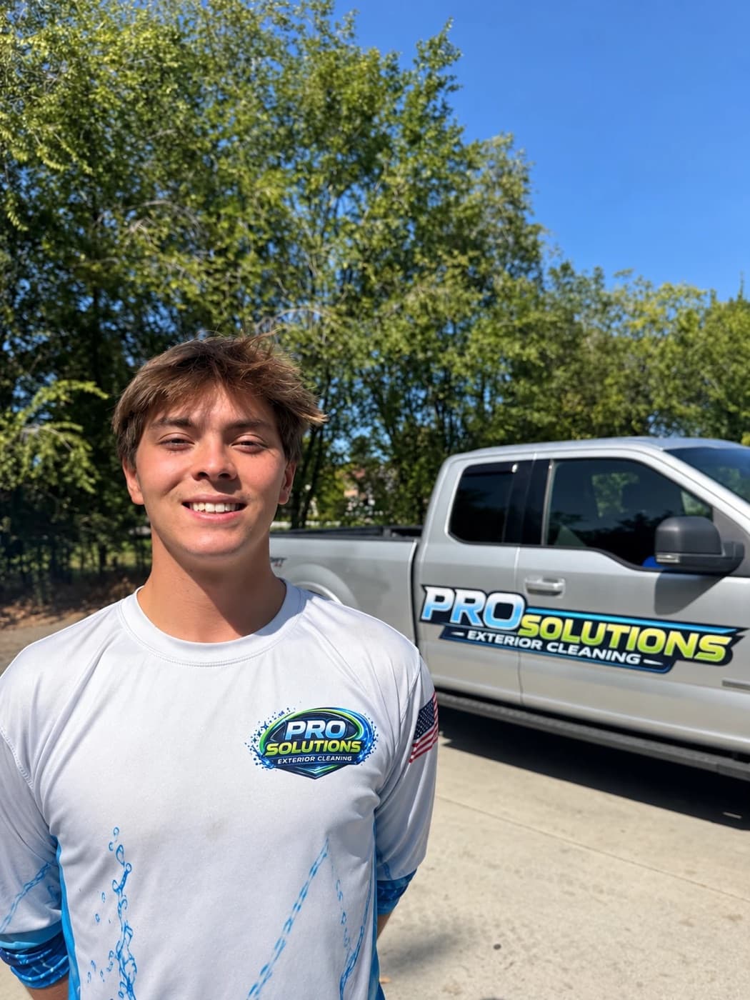 Kody Walgren, owner of Pro Solutions Exterior Cleaning, next to a Pro Solutions truck