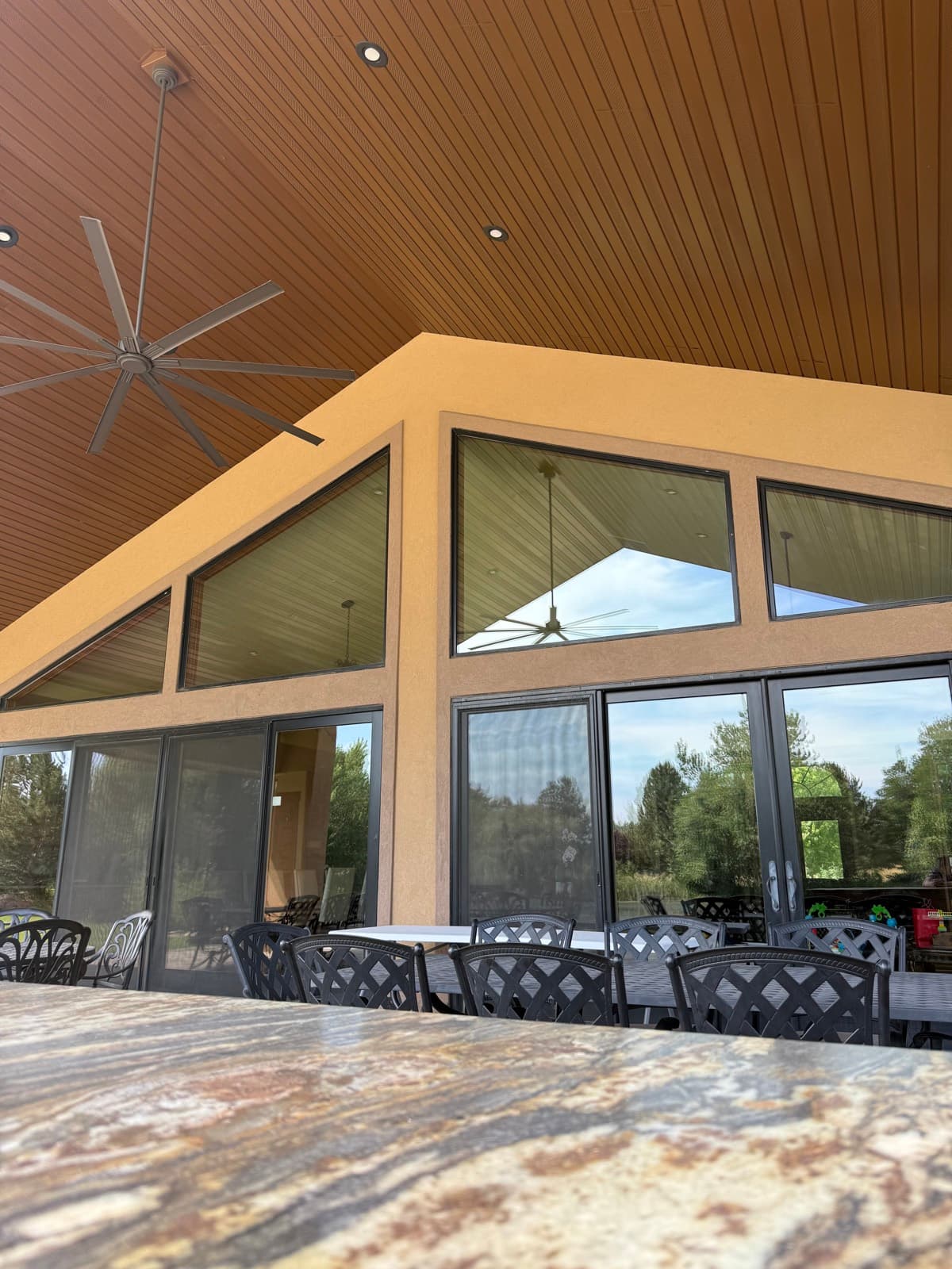 Covered-patio gable window wall under a wood ceiling, cleaned spot-free