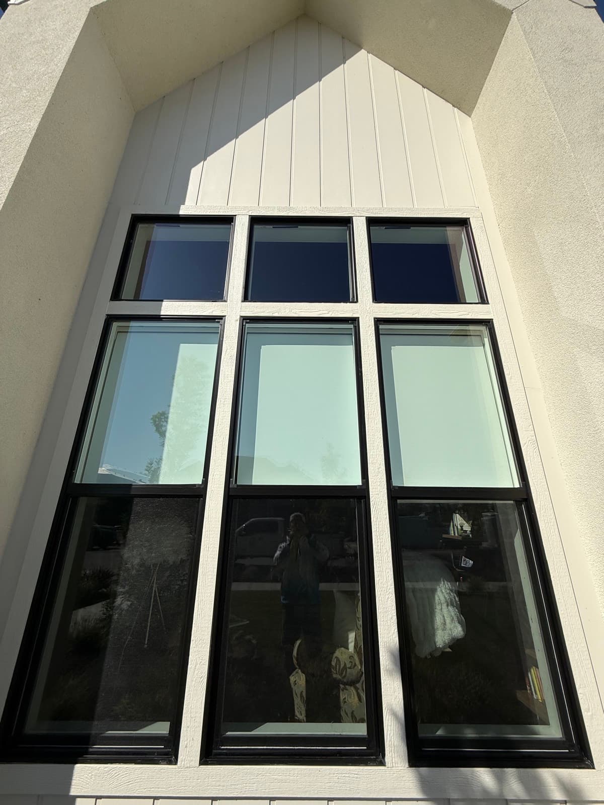 Two-story black-frame window wall on a modern farmhouse