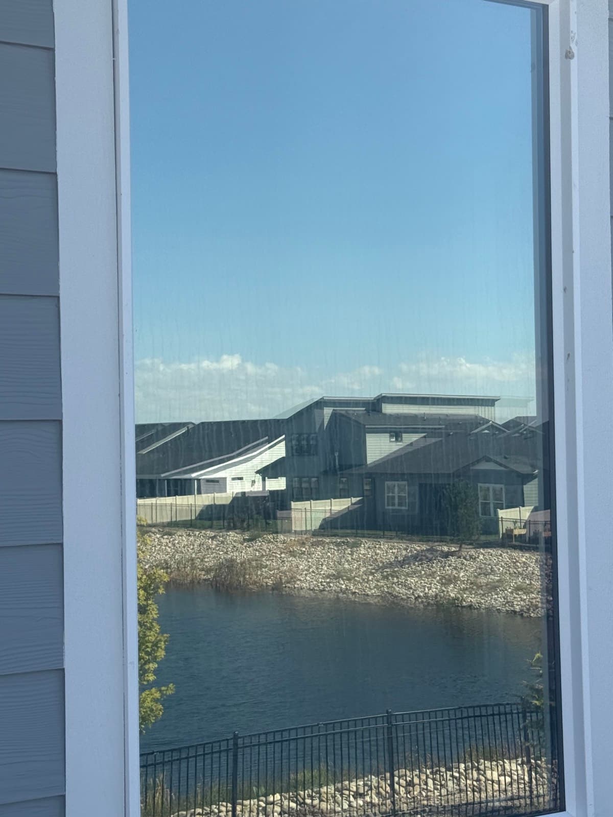 Clean window reflecting a neighborhood pond