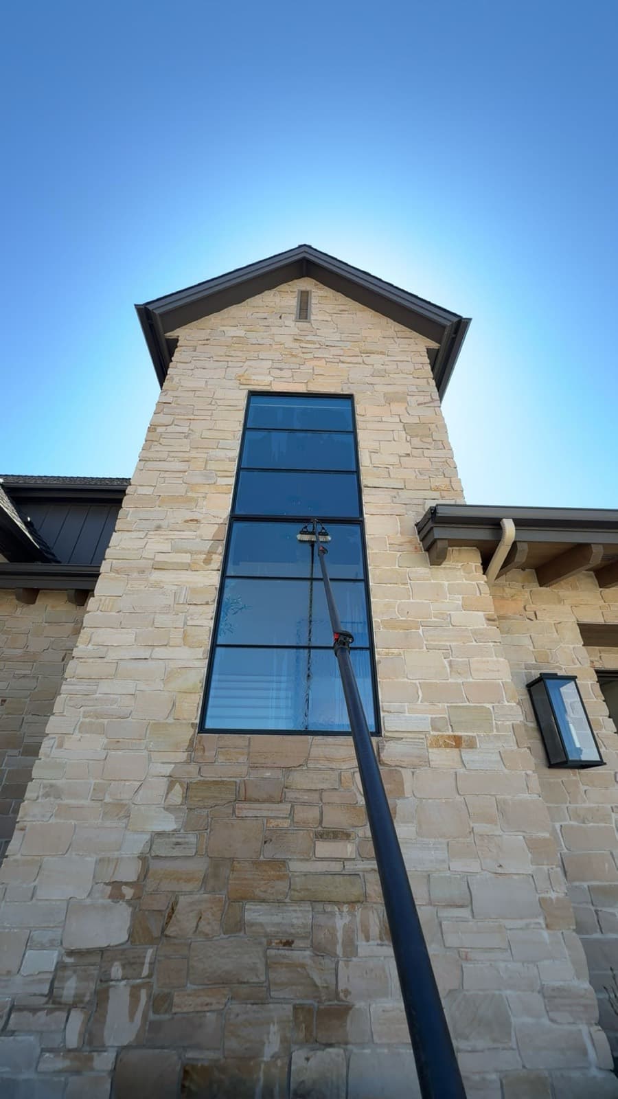 Tall architectural window on a stone tower, cleaned with a water-fed pole